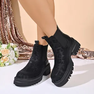 Close-up detail of women chunky platform chelsea boots with subtle leopard texture and embroidery.