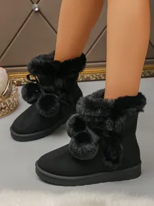 Comfortable stylish black plush snow boots with cute pom poms and thick platform soles.