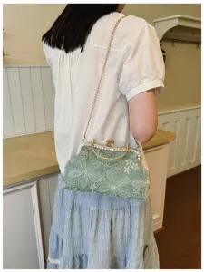 Elegant green embroidered evening bag with chain strap, perfect for special occasions.