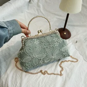 Elegant sage green lace evening bag with vintage kiss lock and detachable gold chain strap.