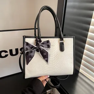 Elegant black and white snake texture tote bag with stylish ribbon scarf, versatile commuter handbag.