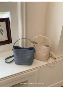Soft woven bucket bag detail shot in minimalist retro scene, chic dual color options.