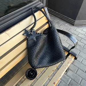 Handgemaakte geweven lederen tote tas met gevlochten band en stijlvolle ster-bedels voor dames.