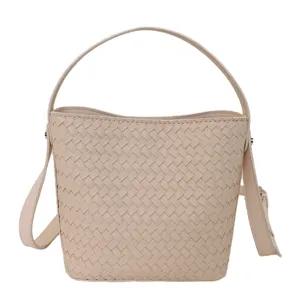 Close-up of woven leather texture detail, soft beige bucket bag craftsmanship, stylish surface.