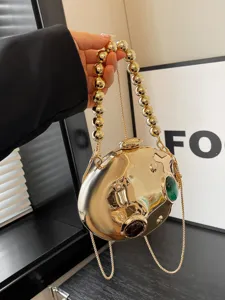 Splendida borsa da sera metallica dorata con manico di perle e design scultoreo unico per le donne.