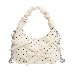 Chic white polka dot faux leather shoulder bag with stylish bow and silver chain strap.