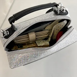 Silberne Glitzer Umhängetasche Detail zeigt Innenkapazität und oberen Griff Design.