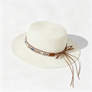 Close-up detail of the bohemian straw sun hat showcasing the beaded braided band and leather bow.