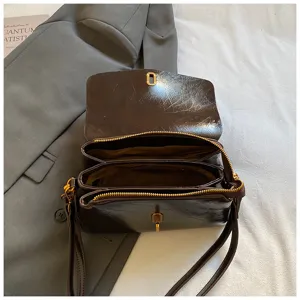 Detailed view of the dark brown glossy women crossbody bag with double zipper and chic lock.