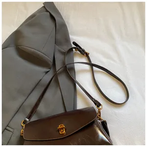 Brown cross-body shoulder bag with glossy leather finish, featuring elegant golden lock hardware.