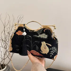Chinese style embroidered evening bag with gold frame handle and chic rabbit pattern design.