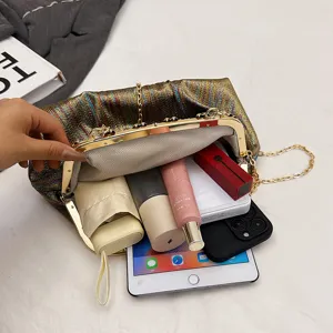 Détail du sac de soirée plissé métallique montrant un intérieur spacieux et un fermoir rétro.