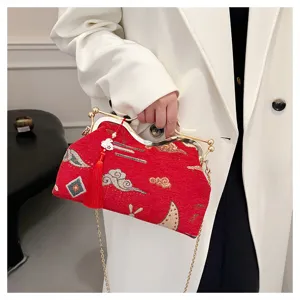 Detailed view of the Chinese style red brocade evening bag with gold frame and tassel.