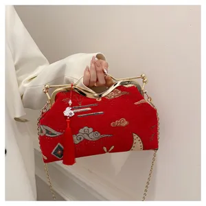 Detailed shot of a red Chinese style embroidered evening clutch with a chic gold chain.