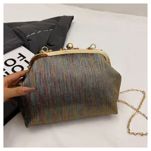 Détail de pochette de soirée métallique scintillante, fermoir élégant et chaîne dorée.