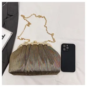 Sac de soirée plissé métallisé avec fermoir strass et chaîne dorée pour robe de fête.