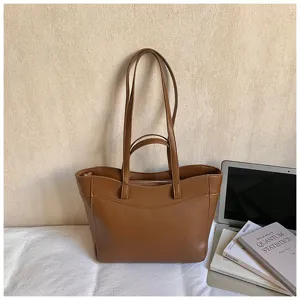 Close-up view of a stylish brown PU leather tote bag with double handles for daily wear.