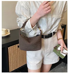 Brown woven crescent shoulder bag for women, retro dumpling handbag with handle details.
