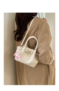 Detailed view of women elegant shoulder handbag with cute winged horse charm and chic clasp.