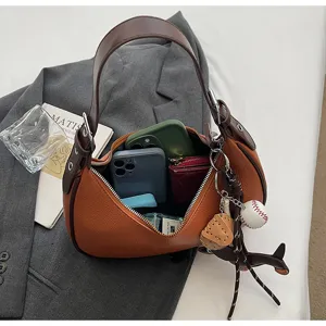 Braune Halbmond Umhängetasche für Damen, stilvolle Hobo Handtasche mit Baseball Anhänger.