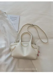 Minimalist solid color leather handbag, detailed view of unique texture and shoulder strap.