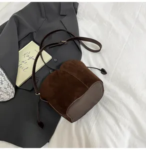Brown suede bucket bag detail view, chic women shoulder handbag with drawstring closure.