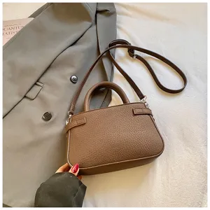 Brown pebbled leather crossbody bag detail, vintage chic top handle shoulder bag for women.