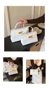 Élégant sac à main blanc pour femmes, sac bandoulière minimaliste avec des garnitures dorées.