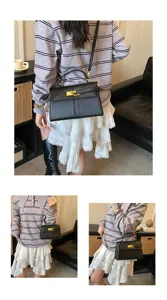 Vue détaillée du sac à main noir élégant en cuir avec des ferrures dorées chics.