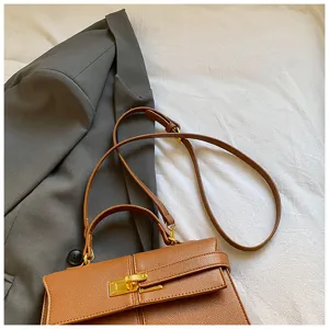 Sac à main marron élégant pour femme, sac bandoulière chic avec serrure dorée.