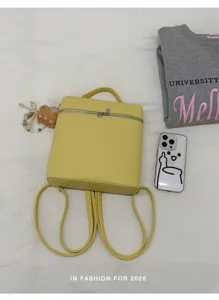 Détail de sac à dos carré jaune minimaliste, sac casual chic en cuir PU pour femmes élégantes.