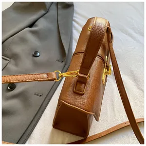 Gros plan élégant d'un sac à main marron en cuir chic doté de superbes détails dorés.