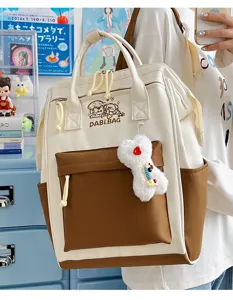Detailansicht des japanischen Segeltuch-Rucksacks in Kontrastfarbe mit süßem Plüsch-Anhänger.