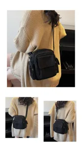 Detail view of a versatile black canvas crossbody camera bag worn by model, multi-pocket design.