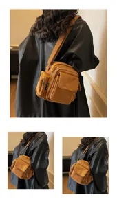 Detail view of the stylish brown canvas crossbody camera bag featuring multi-pocket design.