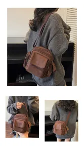 Detailed view of the vintage brown multi-pocket canvas crossbody bag worn by the model.