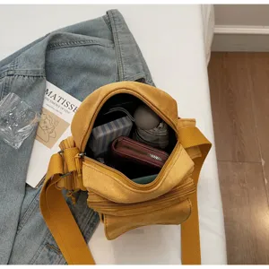 Yellow canvas camera bag for women, versatile crossbody shoulder bag with multiple zipper pockets.