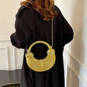 Detailed view of the stylish gold metal round handle crossbody bag with chic ribbed texture.
