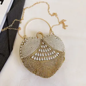 Heart-shaped pearl rhinestone evening bag clutch with metal ring handle and chain strap.