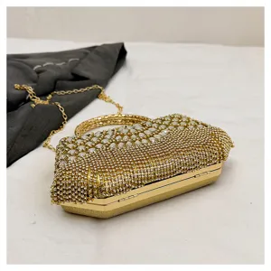 Gold rhinestone evening clutch bag detail showing sparkling crystals and metallic chain strap.
