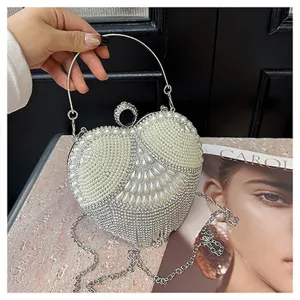Heart-shaped pearl rhinestone evening clutch bag with metal ring handle and chain strap detail.