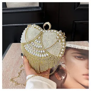 Heart-shaped evening clutch bag adorned with pearls and rhinestones featuring a metal ring handle.