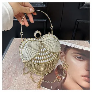 Heart-shaped rhinestone pearl evening bag detail, elegant metallic ring handle clutch purse.