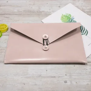 Pink leather envelope document bag detail shot, PU file storage folder with button closure.