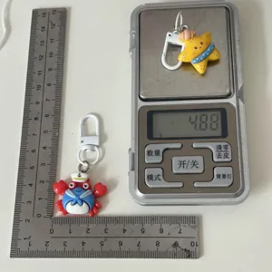 Detail view of cute marine animal keychain featuring crab and starfish designs with metal hook.