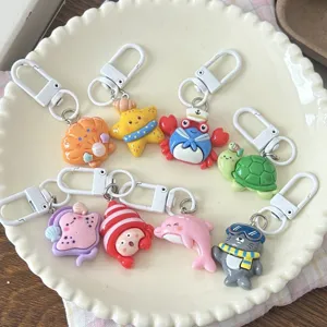 Cute marine animal keychain detail, featuring cartoon resin crab, turtle, and shell designs.