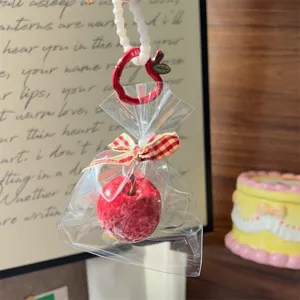 Detalle de llavero de manzana roja, lindo dije de bolso con lazo y correa de cuentas.
