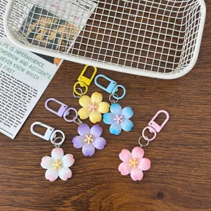 Close-up detail of pastel cherry blossom flower keychains in various sweet colors for daily use.