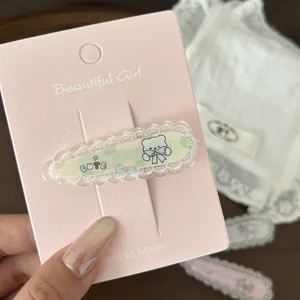 Close-up of cute lace hair clip with adorable bear design and sweet pink backing card detail.