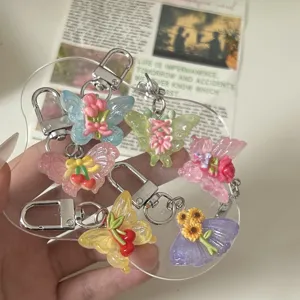 Gedetailleerd overzicht van kleurrijke vlinder sleutelhangers met bloemen en kersen bedels.